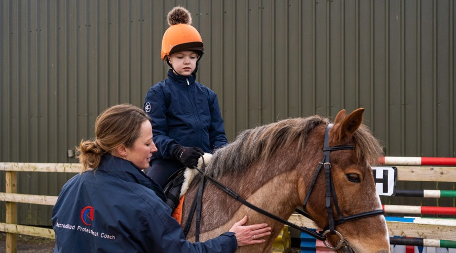 Accredited Professional Coach coaching child on horse
