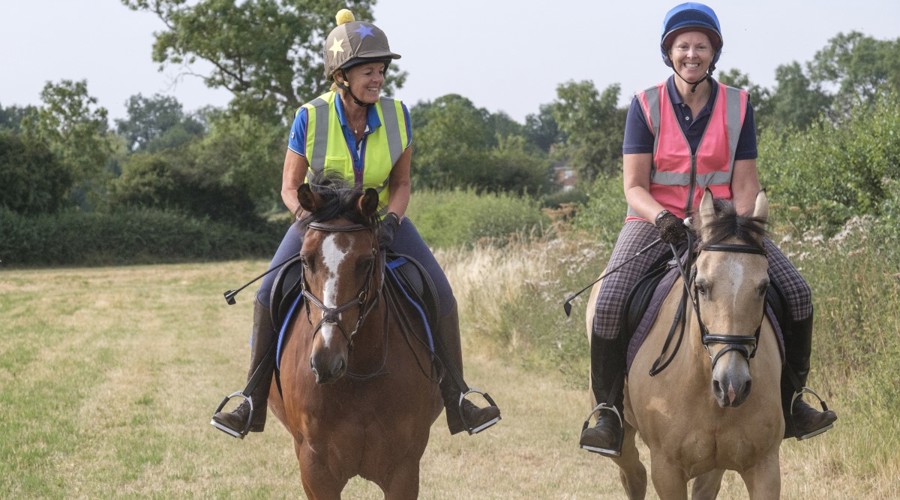 two smiling riders on horses